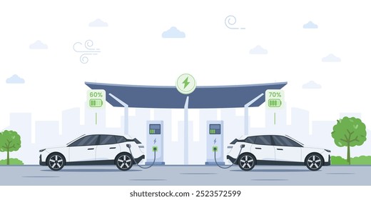 Two electric cars charge at a station under a solar-powered canopy with a city skyline silhouette. Battery EV vehicles are plugged and get electricity from the charging module.