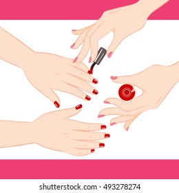 Two female hands getting manicure service of red nail polish