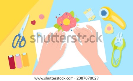 Two female hands with a layout of sewing tools