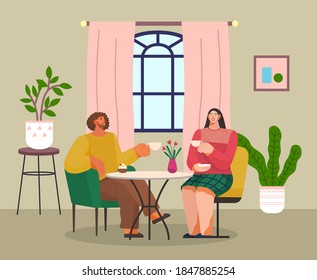 Two friends have lunch or dinner sitting at table at home or in cafe. Couple of guy and girl talking, communicating with cup of tea or coffee. People eating sweet cake. In love couple at date