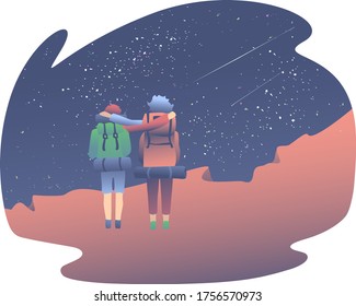 Two friends with large hiking bags stand on the edge of the canyon and look at the starry sky. Camping concept with loved ones.