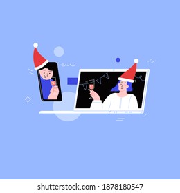 Two friends wearing santa hats on the online conference christmas party. Friends meeting up online. Party from home via videocall on laptop and phone screen