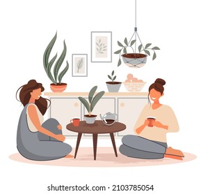 Two girls are drinking tea and talking while sitting on the floor. Vector illustration.