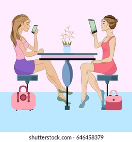 Two girls with gadgets sitting in the cafe 