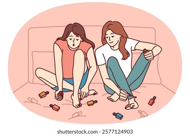 Two girls paint nails sitting on bed and doing pedicure before going to beach or party. Women friends paint toenails with varnish of different colors, wanting to be beautiful and elegant.