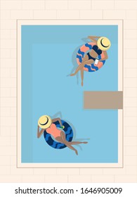 Two girls resting in a pool on inflatable circles with the tablet and cocktails.