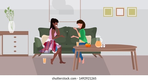 two girls sitting on couch mix race women couple discussing during meeting modern living room interior flat full length horizontal