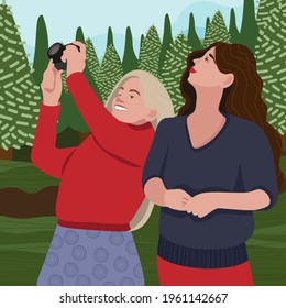 Two girls are walking in the park and one of them is taking pictures of nature
