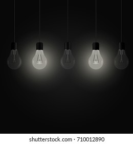 Two glowing bulbs among other light bulbs on a dark background