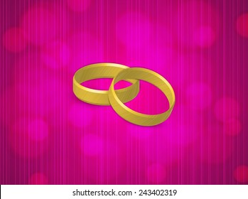 two gold rings on pink blurred background