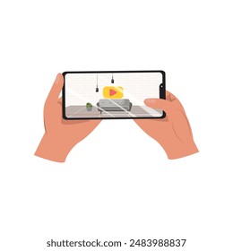 Two hands holding a cellphone displaying a video of a cozy living room setup with a couch, lamps, and interior design elements
