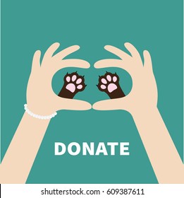 Two hands holding cute cat dog paw print. Love and care pet animals. Helping hand concept. Donate text. Flat design. Green background. Template. Vector illustration