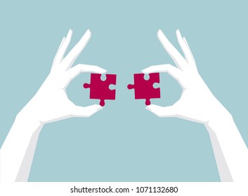 Two hands holding puzzle, hand is white.