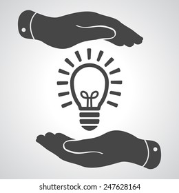 two hands protecting black idea light lamp bulb icon on a grey background - vector illustration