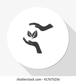 Two hands protecting a leaf.