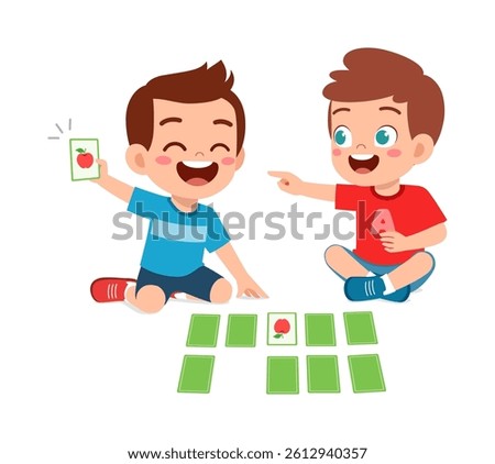Two happy boys playing card game sitting on the floor, smiling and pointing happily.