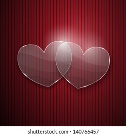 Two hearts from glass on red striped background