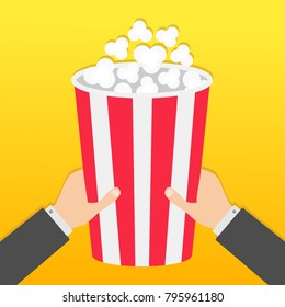 Two human businessman hands holding big popcorn box. Movie Cinema icon in flat design style. Pop corn. Fast food. Yellow gradient background. Vector illustration