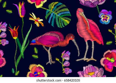 Two Ibises in the blooming garden. Seamless vector pattern with embroidery texture. Tulips, hibiscus flowers, palm leaves. Textile design with oriental motifs.