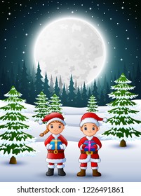 Two kids in santa claus holding a gift box with winter background at night