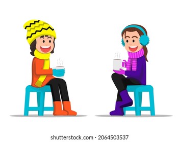 Two little girls chatting together while holding a hot drink