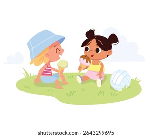 Two little girls are sitting on the grass lawn, enjoying ice cream on a bright summer day, ball is lying nearby.