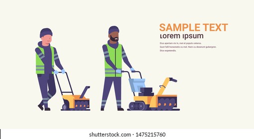dos trabajadores uniformados que utilizan el servicio de limpieza de nieve de nieve eliminación de nieve calle invierno servicio de limpieza de la mezcla limpiadores de carreras equipo empujando el lanzador de nieve de longitud plana completa espacio de copia horizontal