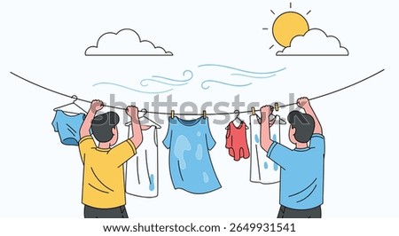 Two men hang laundry outdoors on a sunny windy day drying clothes