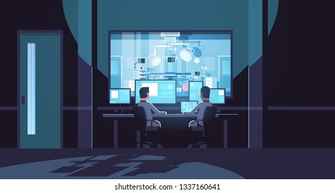 Two Men Looking At Monitors Sitting Behind Glass Window Hospital Operating Table Medical Surgery Room Dark Office Interior Surveillance Security System Flat Horizontal