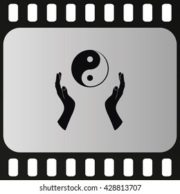 Two opened hands holding Yin Yang symbol.