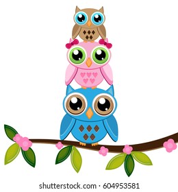 two owls with baby on a branch