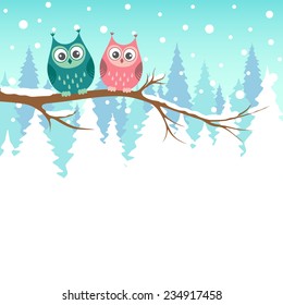 Two owls on a branch in winter forest