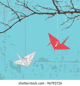 Two paper cranes hanging on tree branch