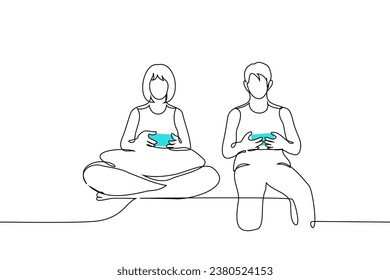 two people man and woman are sitting next to joysticks in their hands, they are playing video games - one line art vector. concept couple or friends playing video game