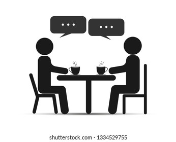 Duas pessoas sentam-se à mesa, tomam chá ou café e conversam