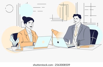 Two people are sitting at a desk with laptops. One of them is smiling. The other person is wearing a suit