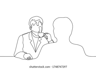 Two people are sitting at a table in an outdoor cafe and drinking tea or coffee. The silhouette of a man sitting with his back to us and the man opposite him dressed in a business suit holding a cup