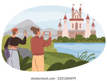 Two people are taking photos of a castle near a lake with smartphones while standing amidst greenery. Mountains are visible in the background. Ideal for tourism, travel, adventure, history