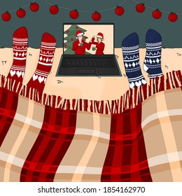 Two people are watching New year and Christmas movie on the bed under the burgundy traditional plaid on laptop in knitted red and blue socks