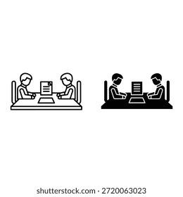 Dos personas trabajando en computadoras en un escritorio con un documento en pantalla