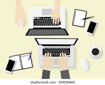  two persons working on their computers. the view from the top. two laptops,