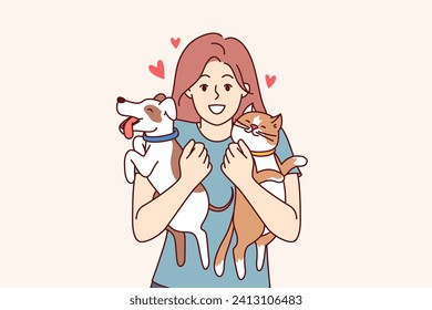 Two pets in hands of teenage girl hugging cat and dog, and feeling love for domesticated animals. Young woman pet owner rejoices at appearance of kitten and puppy, standing among pets