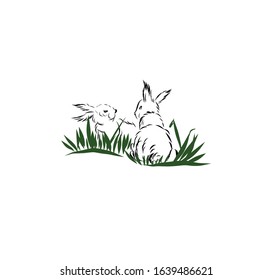 two rabbits or hares are sitting in the grass