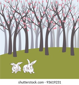 two rabbits on green meadow with forest background