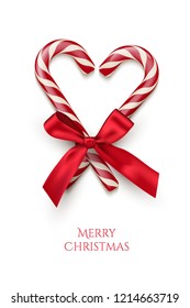 Two red striped candy cane in heart shape with red bow and Merry Christmas text isolated on white background. Vector Christmas design element