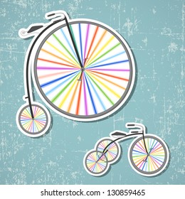 Two retro bicycles with rainbow colored wheels on grunge background