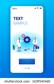 two robots holding cog wheel brainstorming process artificial intelligence technology teamwork concept smartphone screen mobile app vertical full length copy space vector illustration