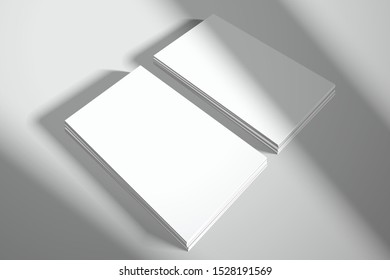 Two stacks of blank white business cards in perspective. Mockup for design or branding with realistic shadows from window