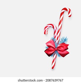 Two striped candy cane sticks with blue fir branch and red bow. Sale tag. Vector holiday illustration.