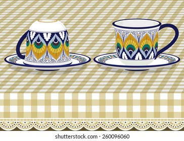 Two tea cups with saucer on checkered tablecloth